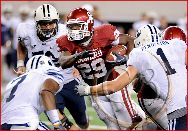 SPORT NCAA FOOTBALL Oklahoma running back Chris Brown #29 carries the ball as he is met by Brigham Young defensive back Brian Logan #7 and Brigham Young linebacker Jordan Pendleton #1
